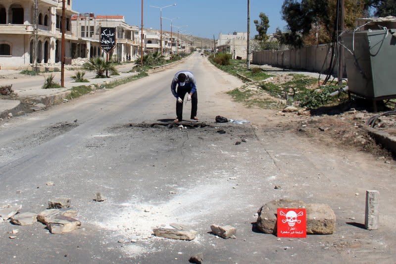 A Syrian man collects samples from the site of a suspected toxic gas attack in Khan Sheikhun, in Syria's northwestern Idlib province, on April 5. On January 21, 2014, a report from three former war-crimes prosecutors said they found evidence of widespread killings and torture by forces of the government of Syria. File Photo by Omar Haj Kadour/UPI