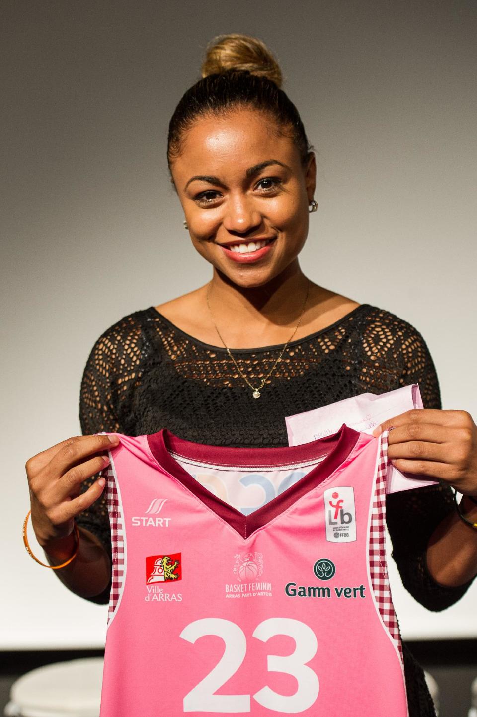 In this photo taken on Sept. 17, 2013, Arras' Dawn Evans, poses for photographers with her team's basketball jersey in Arras, northern France. Evans, one of the nation's leading scorers for three years as a point guard at James Madison, has left her professional team in France and returned to Tennessee to prepare for a kidney transplant. (AP Photo/Pascal Bonniere, VDN)