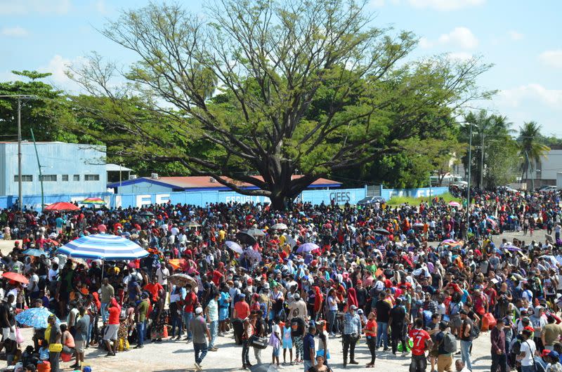 Migrants, mostly Haitians, queue outside a stadium to apply for humanitarian visas, in Tapachula
