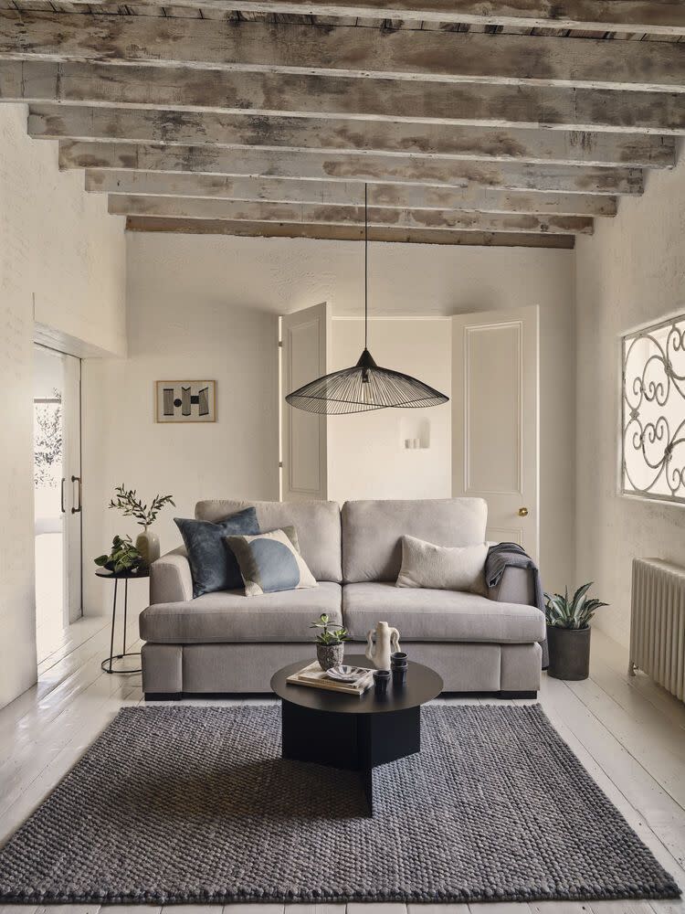 <p>This contemporary living room is a great example of how much warmth a greige colour scheme can add. If a crisp white wall was used here, the grey sofa and black accessories would become cooler and more contemporary. Greige is often an easy way to soften a room with lots of modern monochromes. <br></p><p>Pictured: <a href="https://www.dfs.co.uk/freya/fye62afry" rel="nofollow noopener" target="_blank" data-ylk="slk:House Beautiful Freya Sofa at DFS;elm:context_link;itc:0;sec:content-canvas" class="link ">House Beautiful Freya Sofa at DFS</a></p>