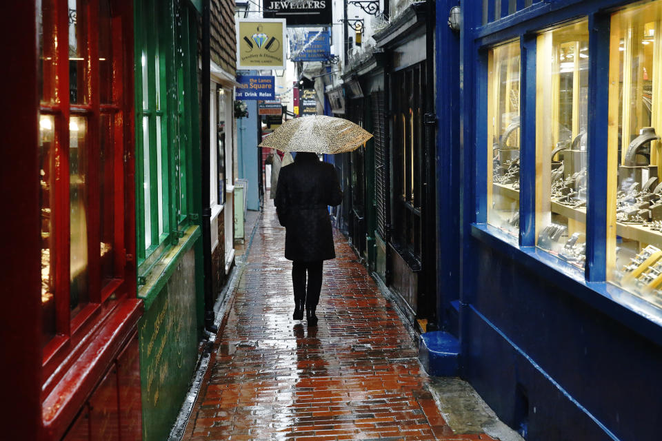 A woman carrying an umbrella walks through "The Lanes" shopping area in Brighton, southern England January 8, 2015.  British businesses enjoyed a strong end to 2014, marked by rising demand at home and abroad and a record number of companies hiring staff, a major business survey showed on Thursday.  REUTERS/Luke MacGregor  (BRITAIN - Tags: BUSINESS ENVIRONMENT)