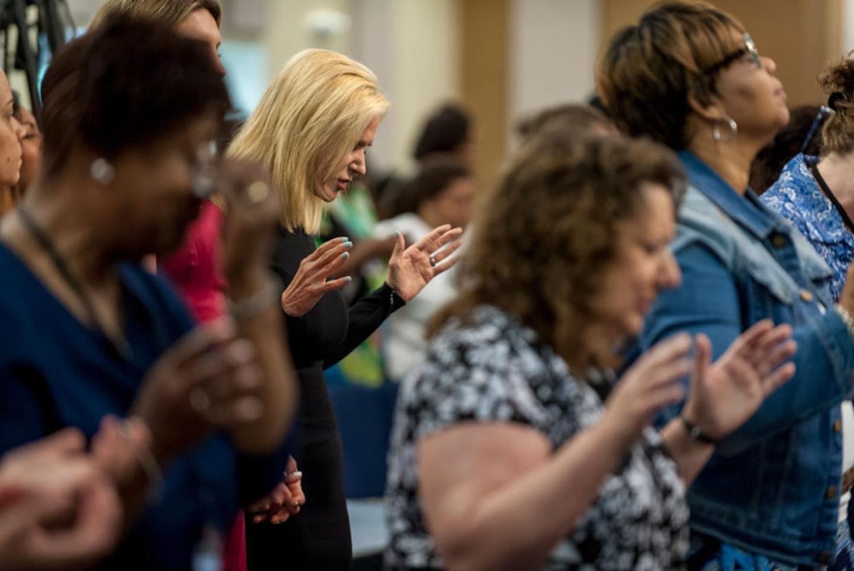 Pentecostal televangelist Paula White, center, prays before giving a sermon in Maryland in 2017. <a href="https://www.gettyimages.com/detail/news-photo/visiting-pastor-paula-white-a-pentecostal-christian-news-photo/873934268?phrase=pentecostal%20church&adppopup=true" rel="nofollow noopener" target="_blank" data-ylk="slk:Mary F. Calvert For The Washington Post via Getty Images;elm:context_link;itc:0;sec:content-canvas" class="link ">Mary F. Calvert For The Washington Post via Getty Images</a>