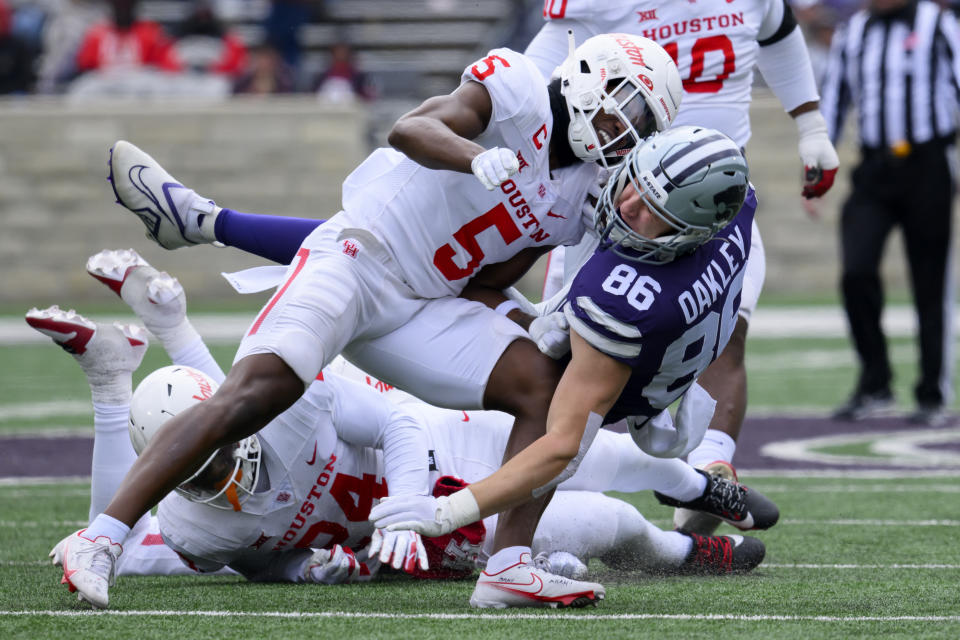 Kansas State tight end Garrett Oakley (86) is tackled by Houston linebacker Hasaan Hypolite (5) during the second half of an NCAA college football game in Manhattan, Kan., Saturday, Oct. 28, 2023. (AP Photo/Reed Hoffmann)