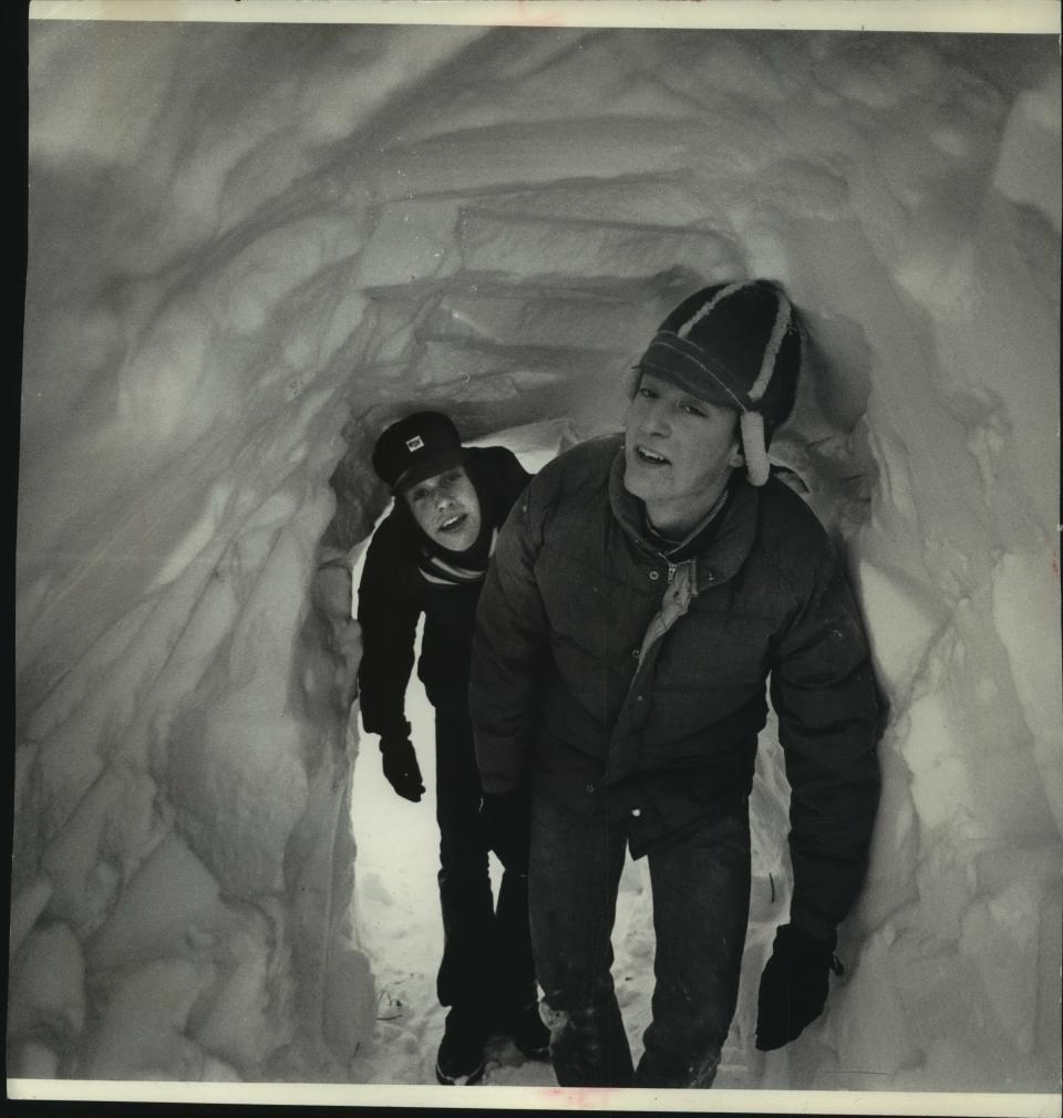 Paul Raddatz and John Maglio, finishers at C.S. Raddatz Leather Co. in Ixonia, enter the company's plant through a tunnel dug through an 11-foot drift that blocked the doorway on Jan. 15, 1979. This photo was published in the Jan. 16, 1979, Milwaukee Journal.