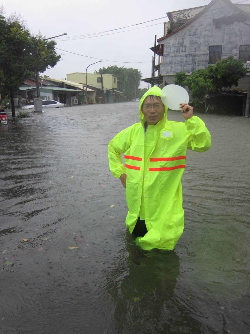 高雄市23日瞬間強降雨不斷，造成多處積水，交通打結。圖為小港區鳳林國小北側門積水，水深及膝。（中央社/民眾提供）