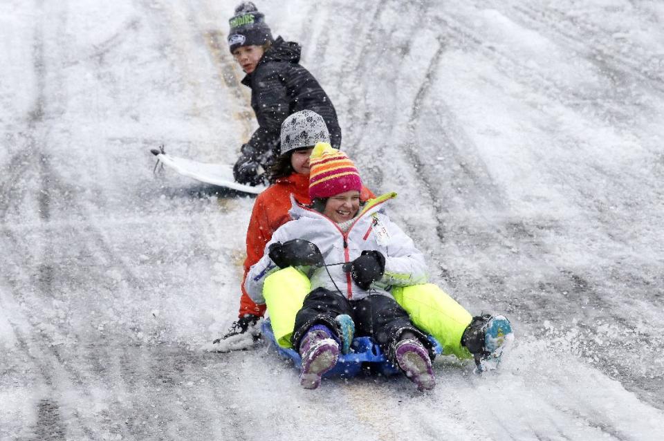 Children sled down a city street closed to traffic during a winter storm moving through the area, Monday, Feb. 6, 2017, in Seattle. Seattle finally got its dose of winter weather, with an overnight storm that left snow totals of an inch to more than a foot across western Washington, causing widespread school closures Monday. (AP Photo/Elaine Thompson)