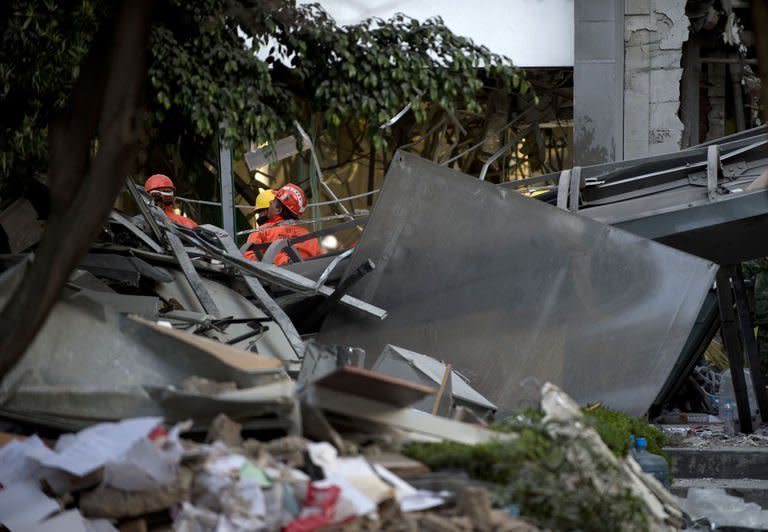 Mexican rescuers search for victims amid the debris of the Pemex headquarters in Mexico City, on February 1, 2013. The death toll in a mystery explosion at the headquarters of Mexico's state-owned oil giant Pemex rose to 32 as rescuers dug through the rubble