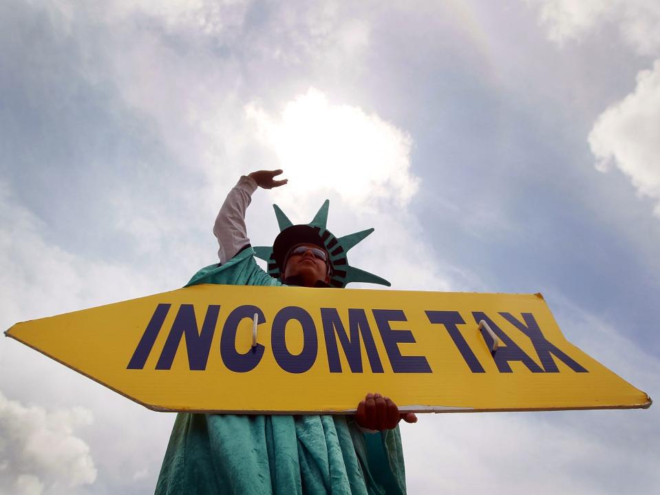 Felipe Castro holds a sign advertising a tax-preparation office for people who still need help completing their taxes before the IRS deadline on April 14, 2010, in Miami.