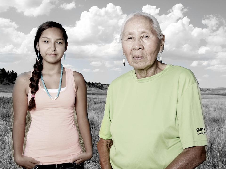 Northern Cheyenne tribe members, a young woman and her grandmother, pose for a portrait.