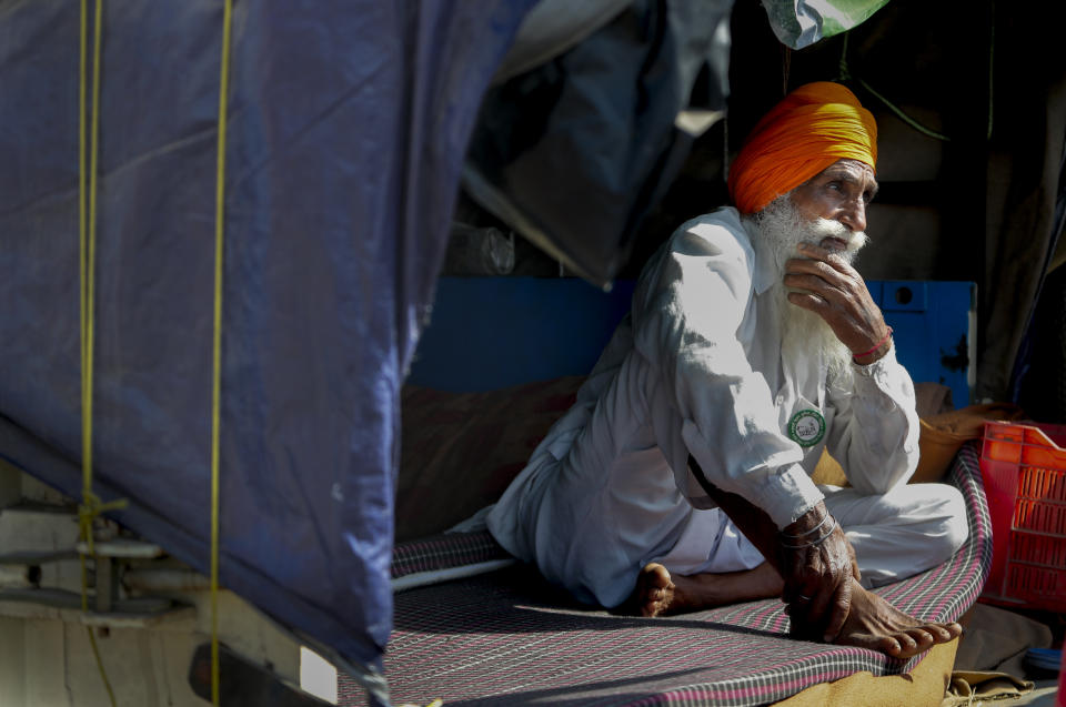 Indian farmer Karnal Singh, 60, sits in the back of his tractor trolly as he camps with others against agricultural laws passed last year that they say will devastate their income, at Singhu, along the Delhi-Haryana border, Friday, March 5, 2021. For 100 days, Singh, has lived inside the back of a trailer, along a vast stretch of arterial highway that connects India’s north with New Delhi. He camped outside the capital when it was under the grip of winter and smog filled the air. Now, New Delhi is bracing for a harsh summer where temperatures sometimes rise to 45 degree Celsius. “We are not going anywhere and will fight till the end,” Singh said on Friday, as he sat cross-legged inside a makeshift shelter in the back of his truck. (AP Photo/Manish Swarup)