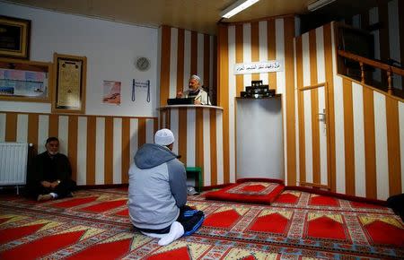 Muslims listen to a Turkish imam during Friday prayers at the moderate Kuba Camii mosque located near a hotel housing refugee's in Cologne's poor district of Kalk, Germany, October 14, 2016. REUTERS/Wolfgang Rattay