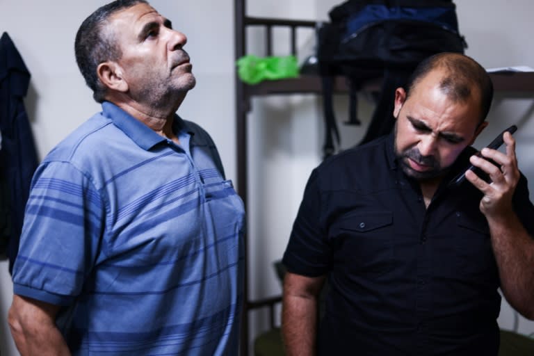 Wissam Mqout (R), can hear the bombing in Gaza when he calls his wife (Kenzo TRIBOUILLARD)