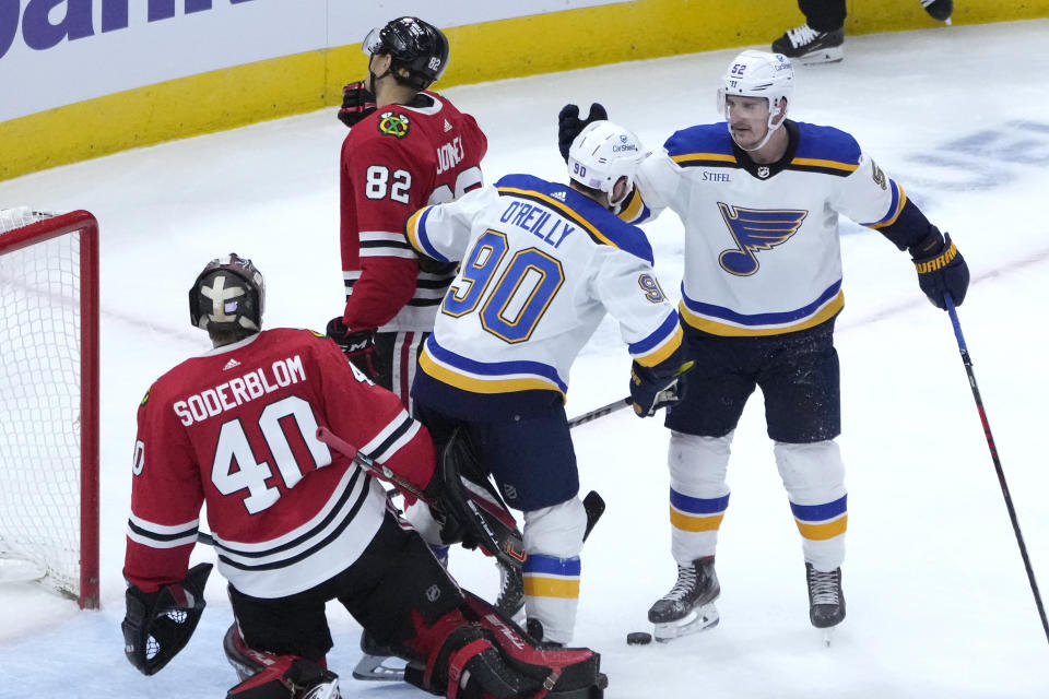 St. Louis Blues' Ryan O'Reilly (90) begins to celebrate his goal with Noel Acciari as Chicago Blackhawks goaltender Arvid Soderblom watches during the second period of an NHL hockey game Wednesday, Nov. 16, 2022, in Chicago. (AP Photo/Charles Rex Arbogast)