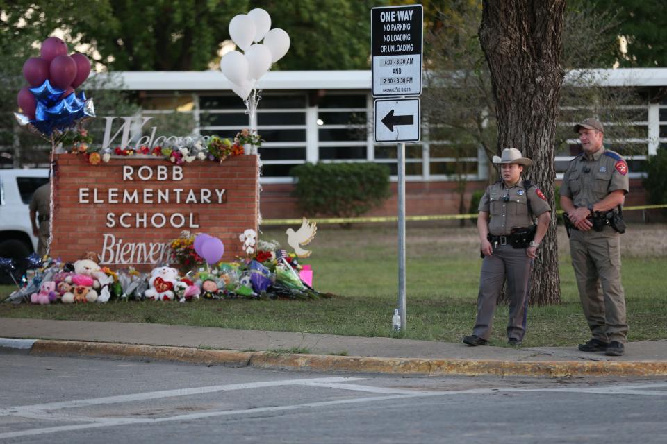 Sheriffs guard people from visiting the memorial outside of Robb Elementary School Wednesday, May 25, 2022. At least 19 students and two adults died in a shooting at a Robb elementary school Tuesday, marking the deadliest school shooting in the state's history.