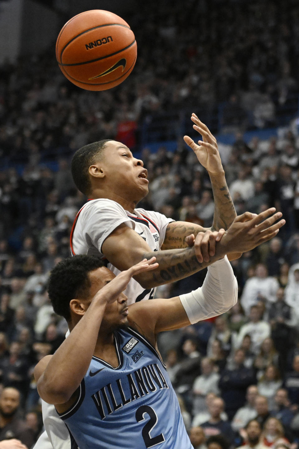 Villanova's Mark Armstrong, bottom, pulls on the arm of UConn's Jordan Hawkins, top, who reaches for a rebound during the first half of an NCAA college basketball game Wednesday, Dec. 28, 2022, in Hartford, Conn. (AP Photo/Jessica Hill)