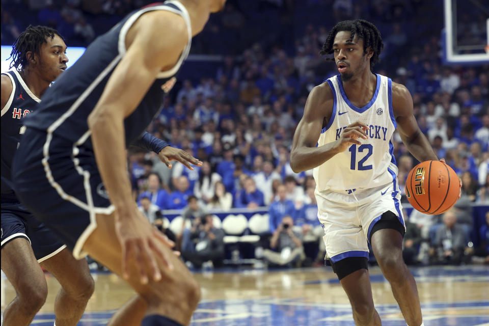 Kentucky's Antonio Reeves (12) looks for an opening on Howard's Bryce Harris, left, during the first half of an NCAA college basketball game in Lexington, Ky., Monday, Nov. 7, 2022. (AP Photo/James Crisp)