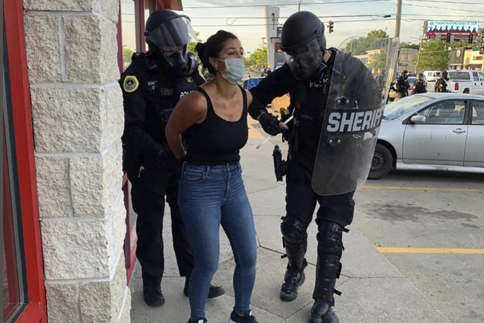 Police officers are shown arresting Des Moines Register reporter Andrea Sahouri after a Black Lives Matter protest she was covering on May 31, 2020. / Credit: Katie Akin / AP