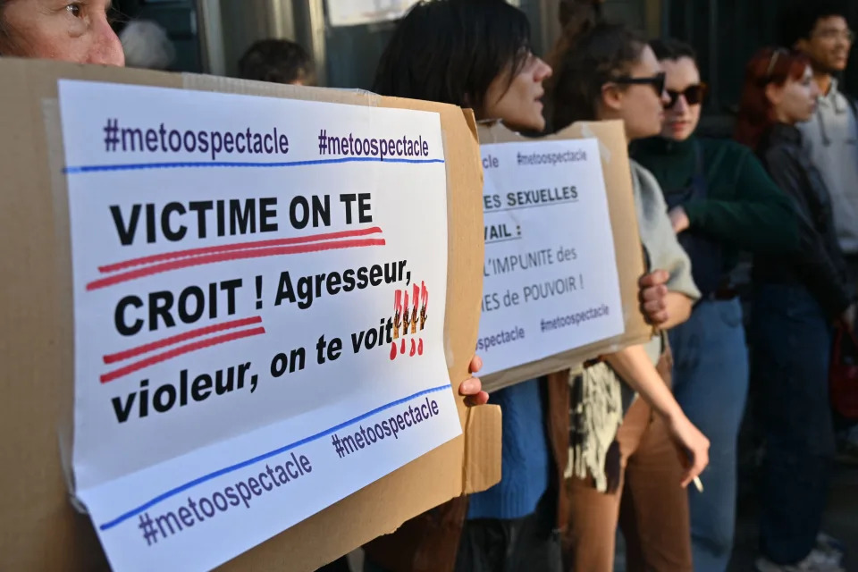 Protesters hold placards which read 