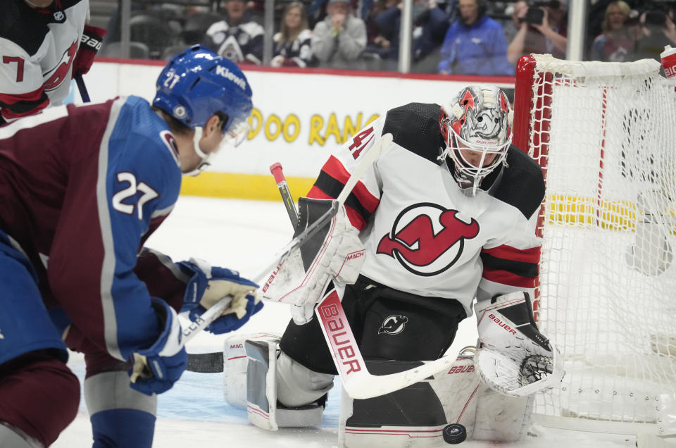 New Jersey Devils goaltender Vitek Vanecek, right, makes a pad save of a shot by Colorado Avalanche left wing Jonathan Drouin in the third period of an NHL hockey game on Tuesday, Nov. 7, 2023, in Denver. (AP Photo/David Zalubowski)