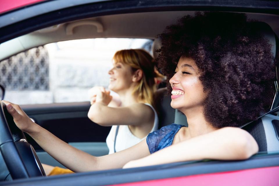 Two friends cruising along in a car, enjoying the radio.