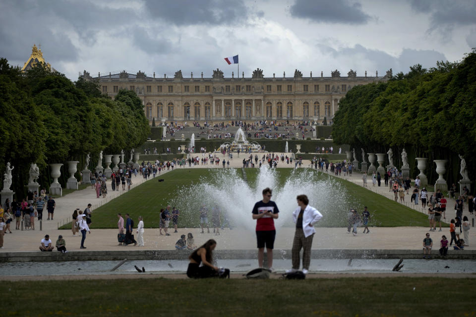 FILE - Visitors enjoy the Chateau de Versailles gardens, outside Paris, France, on July 15, 2023. The Louvre Museum in Paris and Versailles Palace evacuated visitors and staff Saturday, Oct. 14, 2023 after receiving bomb threats. The government has put France on high security alert after a fatal school stabbing by a suspected extremist. (AP Photo/Christophe Ena, File)