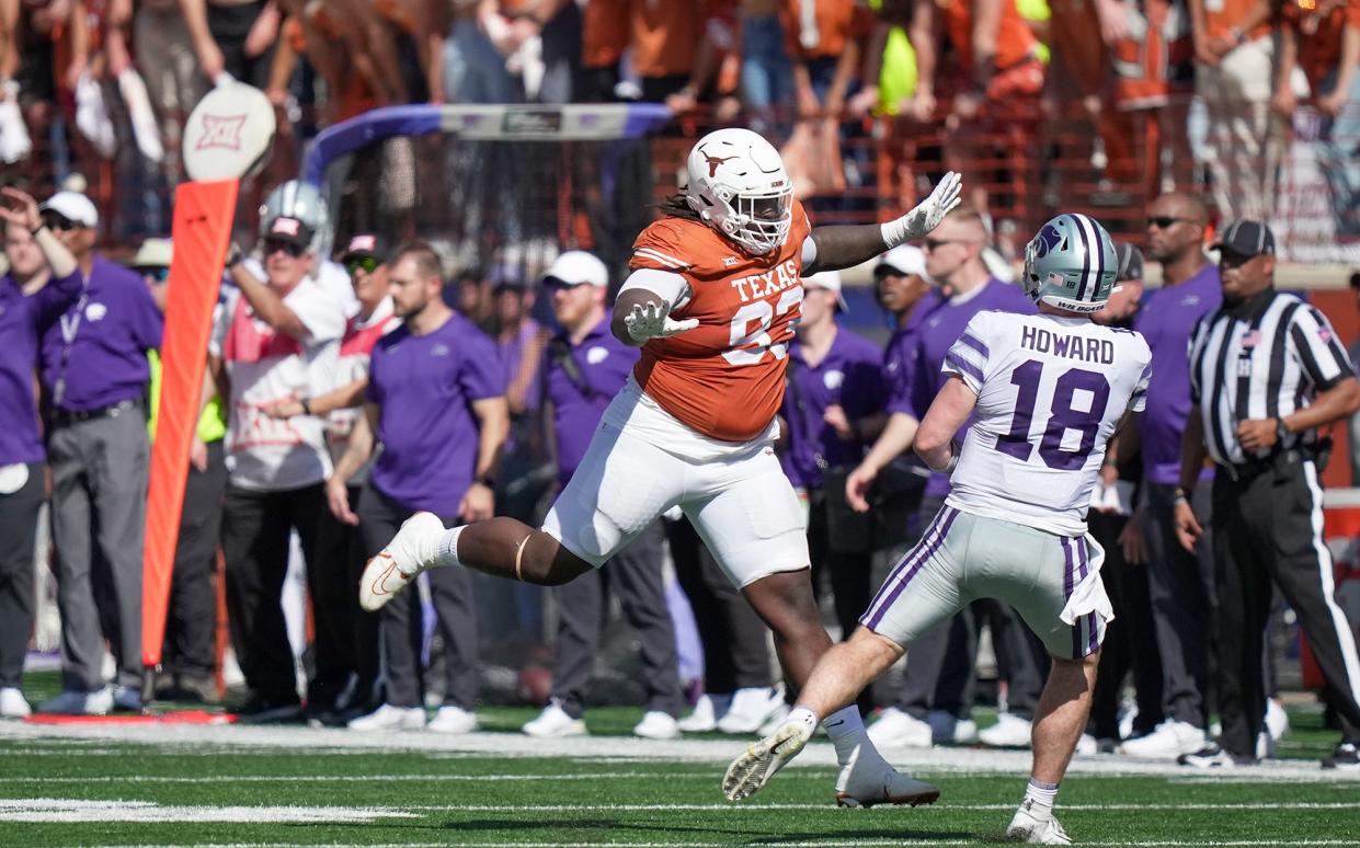 Texas  defensive lineman T'Vondre Sweat lunges for the ball and Kansas State Wildcat quarterback Will Howard in Saturday's 33-30 overtime win. Sweat's disruptive play has been a key to Texas' defense this season. Half of is 13 solo tackles have come behind the line of scrimmage.