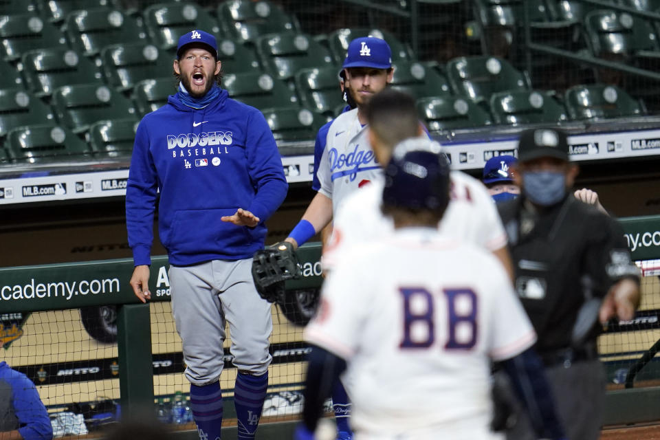Los Angeles Dodgers' Clayton Kershaw, left, yells toward Houston Astros' Carlos Correa after the sixth inning of a baseball game Tuesday, July 28, 2020, in Houston. Both benches emptied onto the field during the exchange. (AP Photo/David J. Phillip)