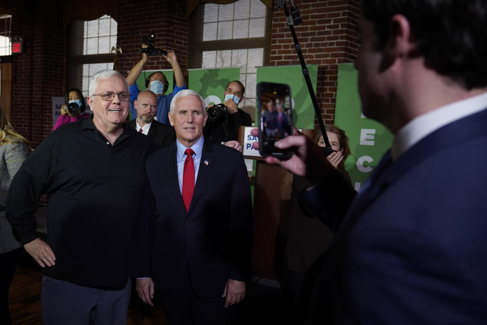 Former Vice President Mike Pence poses for photographs with guests during a gathering, Wednesday, Dec. 8, 2021, in Manchester, N.H. (AP Photo/Charles Krupa)