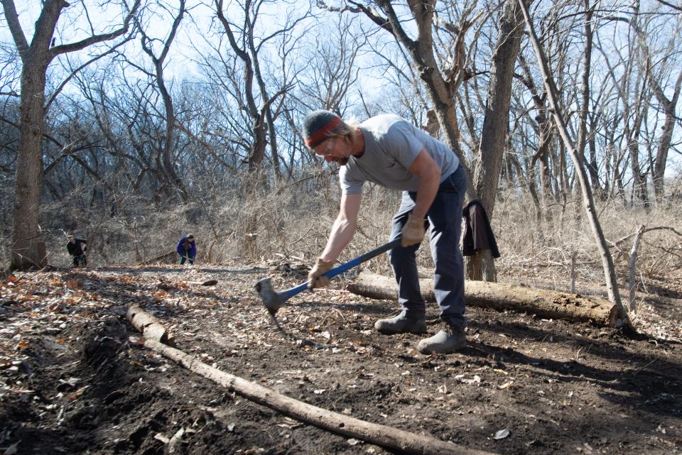 Trevor Dabney uses a Pulaski axe to grade a new section of trail and form a switchback at Kaw River State Park.