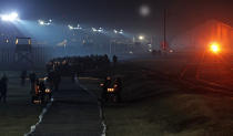 Holocaust survivors and diginitaries arrive to put candles at a memorial site at the Auschwitz Nazi death camp in Oswiecim, Poland, Monday, Jan. 27, 2020. Survivors of the Auschwitz-Birkenau death camp gathered for commemorations marking the 75th anniversary of the Soviet army's liberation of the camp, using the testimony of survivors to warn about the signs of rising anti-Semitism and hatred in the world today. (AP Photo/Czarek Sokolowski)