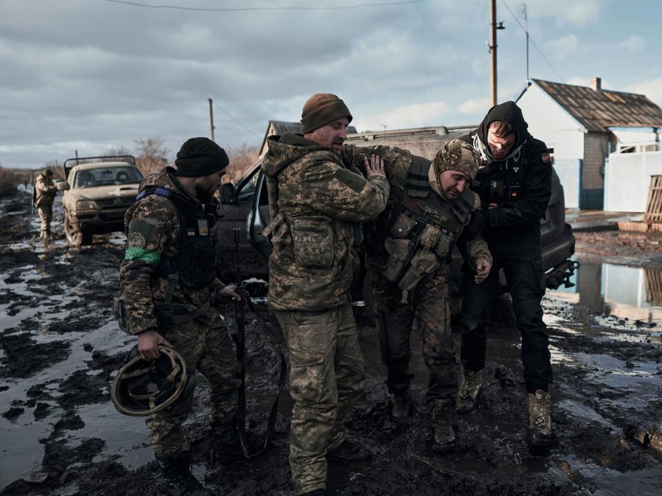 Ukrainian soldiers help a wounded comrade into an evacuation vehicle in the frontline in Bakhmut, Donetsk region, Ukraine, Monday, Feb. 20, 2023.