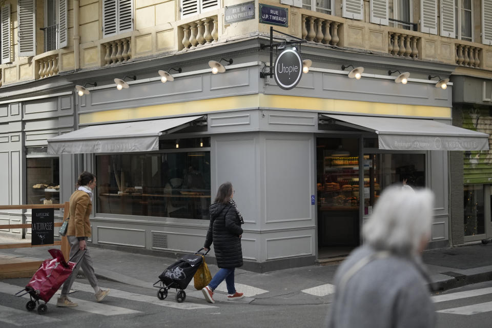 Parisians walk by the Utopie bakery Friday, April 26, 2024 in Paris. Baker Xavier Netry was chosen this week as the 31st winner of Paris' annual "Grand Prix de la baguette" prize. The Utopie bakery in Paris' 11th district that Netry works for wins 4,000 euros ($4,290) and becomes one of the suppliers of the presidential Elysee Palace for a year. (AP Photo/Thibault Camus)