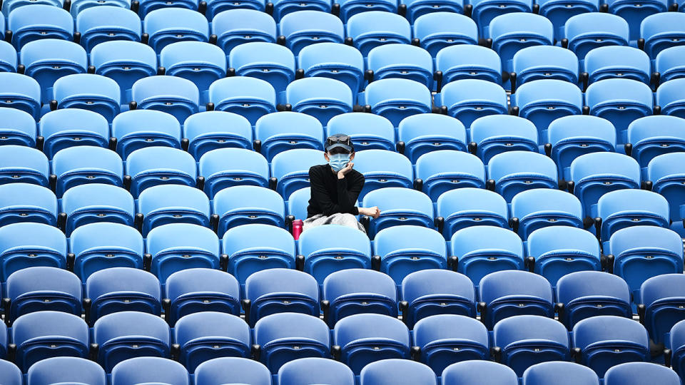 A spectator, pictured here wearing a mask in Rod Laver Arena.