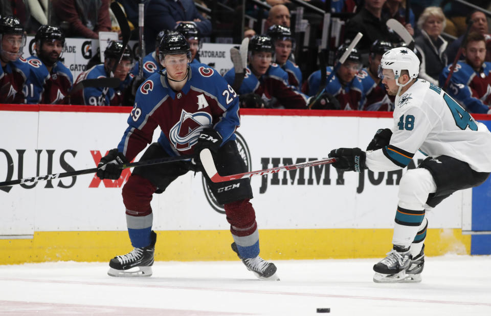 Colorado Avalanche center Nathan MacKinnon, left, watches the puck as San Jose Sharks center Tomas Hertl defends during the second period of an NHL hockey game Thursday, Jan. 16, 2020, in Denver. (AP Photo/David Zalubowski)