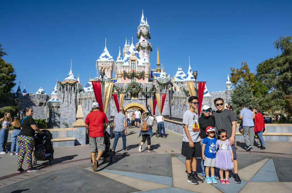 ANAHEIM, CA - November 13: Visitors stop to have their photo taken in front of the Sleeping Beauty Castle decorated for the holidays at the end of Main Street in Disneyland on Saturday, November 13, 2021, in Anaheim. (Photo by Mark Rightmire/MediaNews Group/Orange County Register via Getty Images)