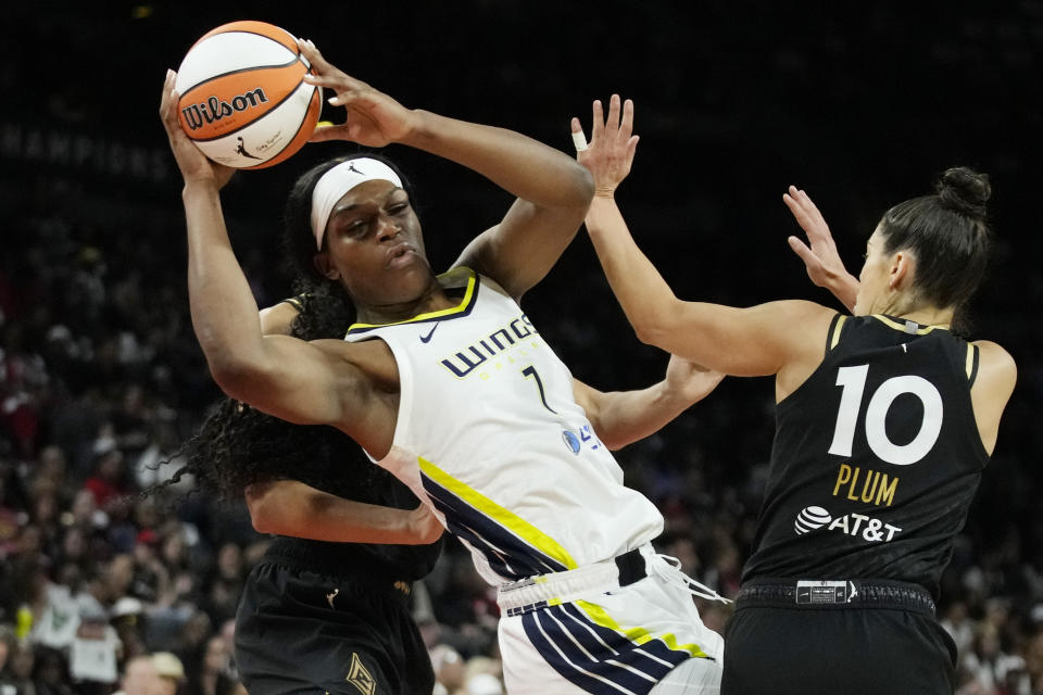 Dallas Wings' Teaira McCowan passes around Las Vegas Aces guard Kelsey Plum (10) during the second half in Game 2 of a WNBA basketball semifinal series Tuesday, Sept. 26, 2023, in Las Vegas. (AP Photo/John Locher)