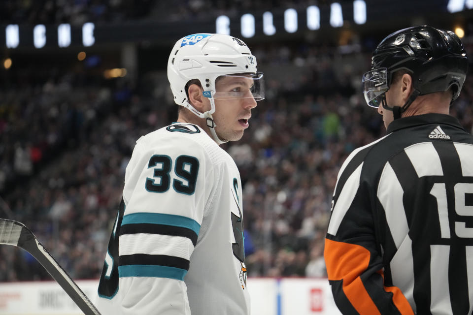 San Jose Sharks center Logan Couture, left, confers with referee Gord Dwyer in the third period of an NHL hockey game against the Colorado Avalanche Tuesday, March 7, 2023, in Denver. (AP Photo/David Zalubowski)