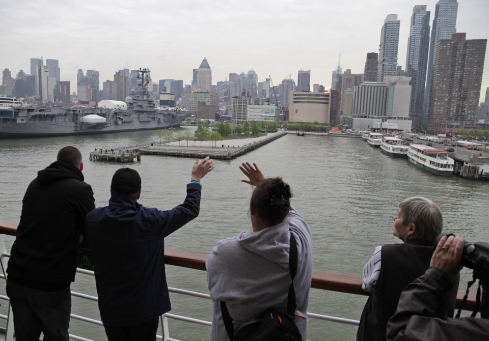 Backdropped by the Manhatan skyline, passengers watch as the MS Balmoral Titanic memorial cruise ship, approaches the New York City port, Thursday, April 19, 2012. Exactly 100 years after the Titanic went down, the cruise retraced the ship's voyage, including a visit Sunday, April 15, to the location where it sank, a stop in Halifax and final destination at New York, as of the original intended trip. (AP Photo/Lefteris Pitarakis)