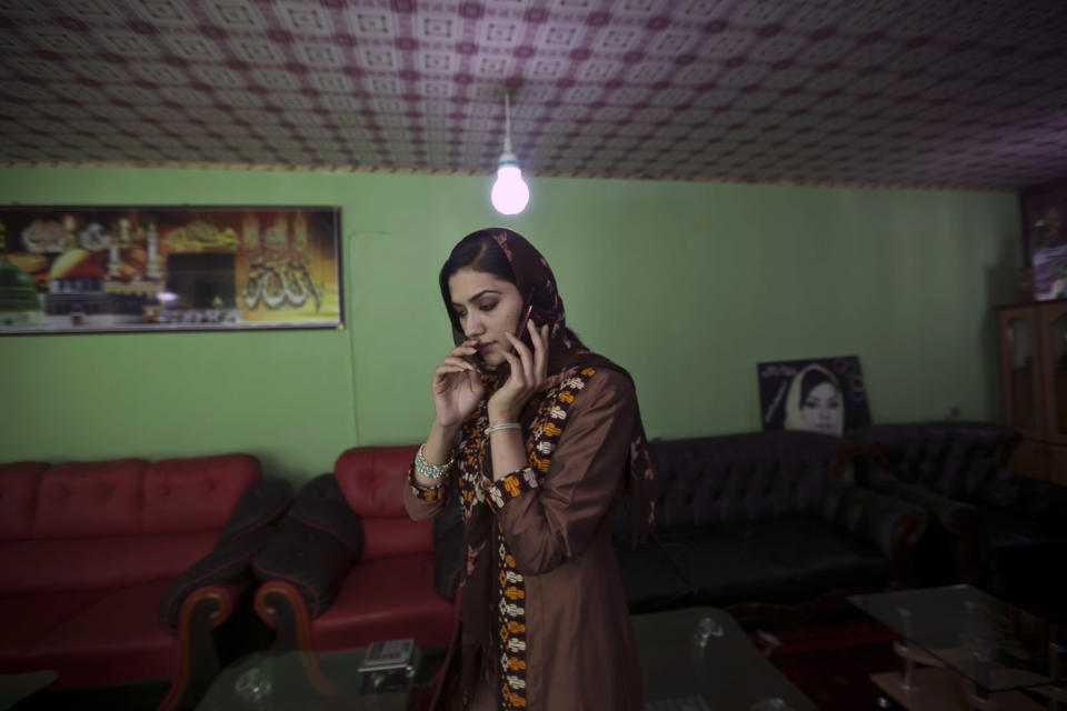 Robina Jelali, an Afghan candidate for the parliamentary election speaks on her phone at her office in Kabul