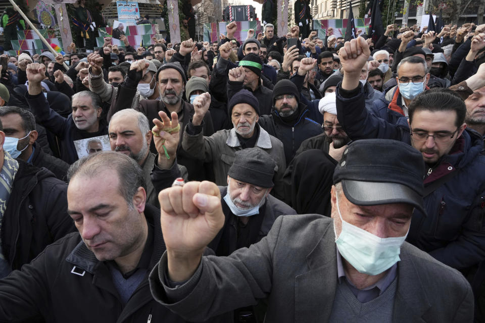 Mourners chants slogans in a funeral procession for a group of unknown Iranian soldiers who were killed during the 1980-88 Iran-Iraq war, whose remains were recently recovered in the battlefields, in Tehran, Iran, Tuesday, Dec. 27, 2022. (AP Photo/Vahid Salemi)