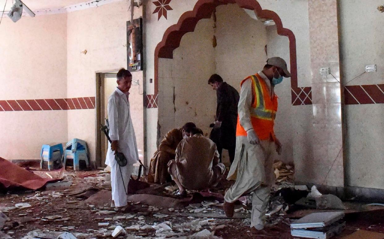 Security officials examine the blast site at a mosque in the town of Kuchlak in southwest Quetta district  - AFP