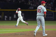 St. Louis Cardinals relief pitcher Giovanny Gallegos pauses at the pitcher's mound after giving up a three-run home run to Arizona Diamondbacks' Eugenio Suarez, left, during the fifth inning of a baseball game Friday, April 12, 2024, in Phoenix. (AP Photo/Ross D. Franklin)