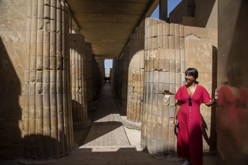 A tourist listens to a guide speak at the entrance of the southern cemetery of King Djoser, after its restoration, near the famed Step Pyramid, in Saqqara, south of Cairo, Egypt, Tuesday, Sept. 14, 2021. (AP Photo/Nariman El-Mofty)