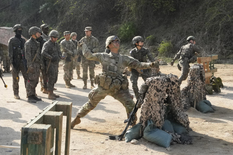 A U.S. Army soldier from the Eighth Army and South Korean army soldiers throw simulated grenades during the Expert Soldier, Infantry, and Medic Badge (E3B) competition at the Rodriguez Live Fire Complex in Pocheon, South Korea, Friday, April 19, 2024. (AP Photo/Ahn Young-joon)