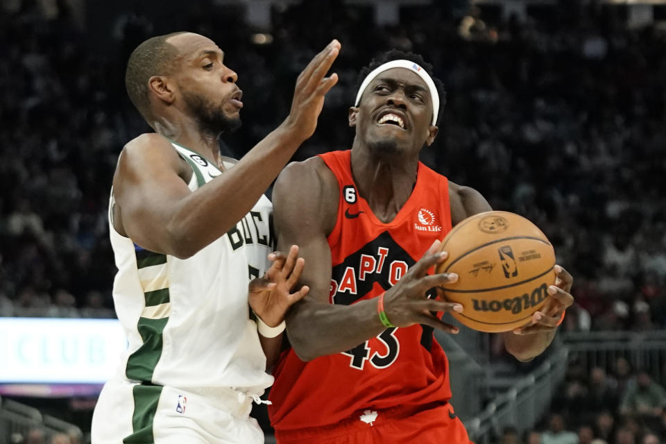 Toronto Raptors' Pascal Siakam, right, drives to the basket against Milwaukee Bucks' Khris Middleton during the first half of an NBA basketball game Sunday, March 19, 2023, in Milwaukee. (AP Photo/Aaron Gash)