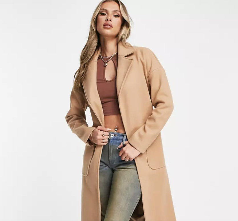 A model wears a Asos SNDYS coat.