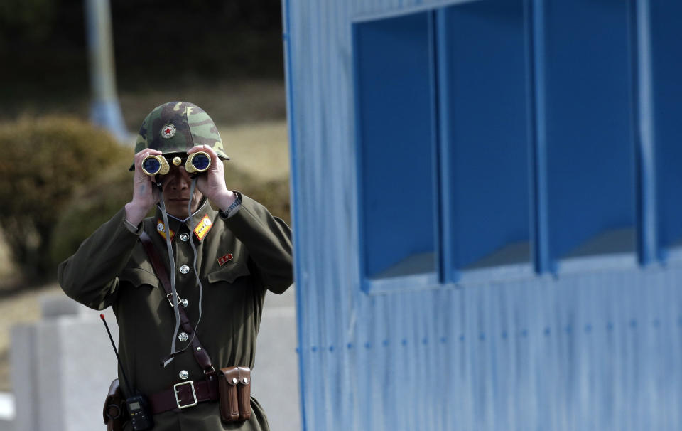 FILE - A North Korean soldier looks at the southern side through a pair of binoculars at the border village of the Panmunjom, in the Demilitarized Zone, DMZ, that separates the two Koreas since the Korean War, in Paju, north of Seoul, South Korea, Tuesday, March 19, 2013. A series of low-slung buildings and somber soldiers dot the landscape of the DMZ, the swath of land between North and South Korea where a soldier on a tour crossed into North Korea on Tuesday, July 18, 2023, under circumstances that remain unclear. (AP Photo/Lee Jin-man, File)