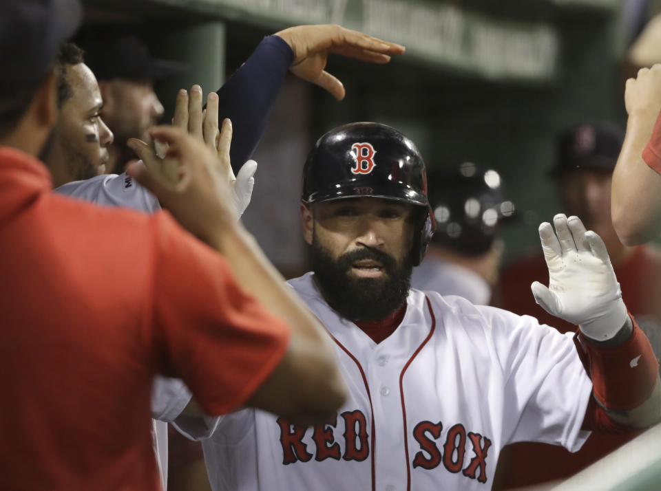 Boston Red Sox's Sandy Leon receives congratulations in the dugout after he hit a solo home run in the fifth inning of the team's baseball game against the Los Angeles Angels at Fenway Park, Thursday, Aug. 8, 2019, in Boston. (AP Photo/Elise Amendola)