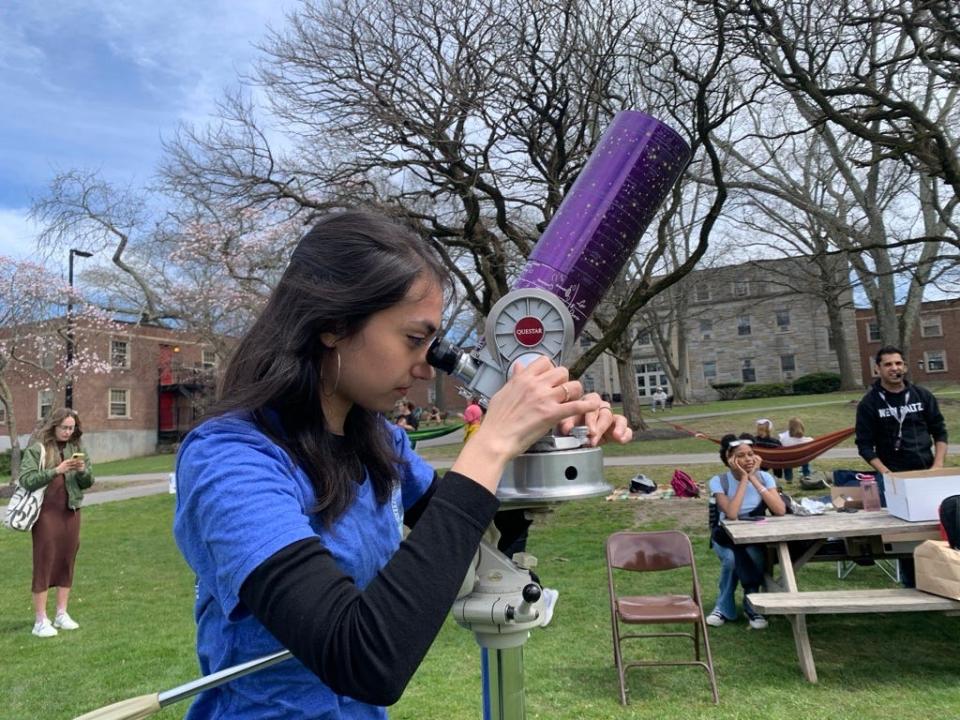 Liliana Kershner, a Physics major at SUNY New Paltz adjusts a telescope prior to the start of Monday’s solar eclipse viewing event Monday, April 8, 2024.