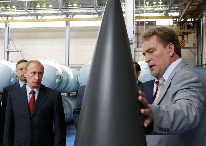 FILE PHOTO: Russian Prime Minister Putin listens to CEO of Almaz-Antey Air Defence firm, Menschikov, during tour of its plant in Moscow